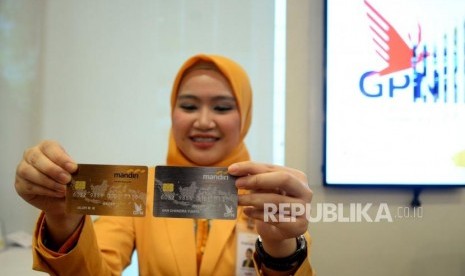 Mandiri Debit Logo GPN. Petugas menunjukan kartu Mandiri Debit berlogo Gerbang Pembayaran Nasional (GPN) di kantor layanan Bank Mandiri, Jakarta, Senin (9/4).