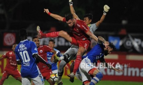 Penyerang Persija Jakarta Marko Simic berduel udara dengan penjaga gawang Persib Bandung M. Natshir dalam laga tunda Liga 1 di Stadion PTIK, Jakarta, Sabtu (30/6).