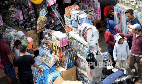 Calon pembeli memilih mainan untuk anaknya ketika berbelanja di Pasar Gembrong, Jakarta,Sabtu (8/6).