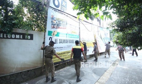 Penertiban Atribut Kampanye. Petugas Satpol PP bersama Badan Pengawas Pemilu (Bawaslu) Jawa Barat menertibkan atribut kampanye, di Jalan LRE Martadinata, Kota Bandung, Jumat (8/3).