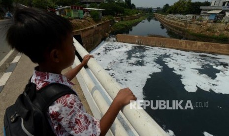 Warga melihat busa yang mengaliri sungai Kanal Banjir Timur (KBT) di Cipinang, Jakarta Timur, Kamis (18/10).