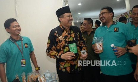 Ketua Umum Gerakan Pemuda Ansor Yaqut Cholil Qoumas (kiri) berbincang bersama Sekretaris Kementerian Koperasi dan UKM Agus Muharam  saat meninjau pameran Ansor Fair 2018 di Jakarta, Ahad (22/4).