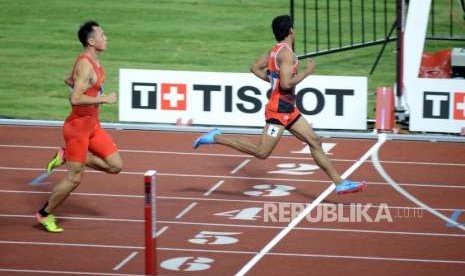 Atlet lari Indonesia Lalu Muhammad Zohri (kanan) tiba di garis finish pada babak kualifikasi cabang olahraga atletik Asian Games 2018 kategori lari 100 meter putra di Stadion Utama Gelora Bung Karno, Jakarta, Sabtu (25/8).