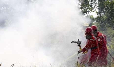 Petugas dari Manggala Agni Daops Banyuasin melakukan pemadaman kebakaran lahan saat simulasi pemadaman Kebakaran Hutan dan Lahan (Karhutla) di posko pemantau Pegayut, Ogan Ilir, Sumatera Selatan, Senin (30/7).