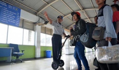 Petugas Dinas Perhubungan (Dishub) kota Surabaya yang menggunakan segway mengarahkan calon penumpang menuju bus di Terminal Purabaya Bungurasih, Sidoarjo, Jawa Timur, Kamis (15/6).