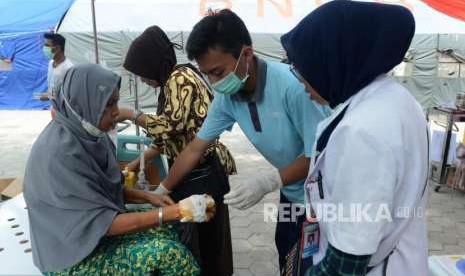 Petugas mengobati warga korban bencana alam gempa bumi dan tsunami dirawat di RSUD Undata, Palu, Sulawesi Tengah, Kamis (4/10).