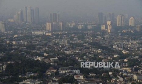 Suasana permukiman dengan latar belakang gedung bertingkat yang diselimuti asap polusi di Jakarta, Rabu (31/7).