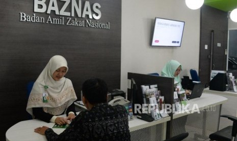 Petugas amil melayani muzaki di counter layanan muzaki Badan Amil Zakat Nasional (Baznas), Jakarta, Rabu (2/1).