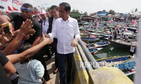 Presiden Joko Widodo menyapa para nelayan di Kampung Nelayan Manggar, Balikpapan, Kalimantan Timur, Kamis (28/3).