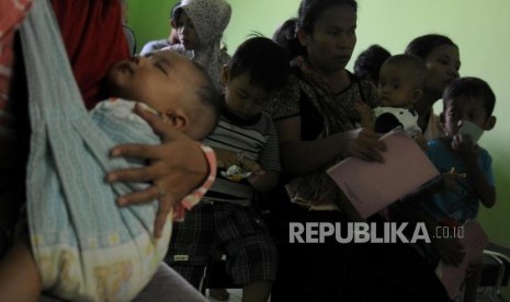 Sejumlah warga mengantre sebelum melakukan imunisasi difteri untuk anaknya di Puskemas Cimanggis, Depok, Jawa Barat, Rabu (6/12).