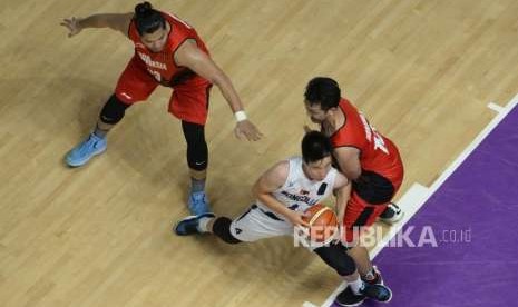 Pebasket Indonesia Ponsianus Nyoman Indrawan dan Valentino Wuwungan berusaha menghadang pemain Mongolia pada pertandingan babak penyisihan Grup A cabang bola basket Asian Games 2018 di Hall Basket Senayan, Jakarta, Sabtu (25/8).