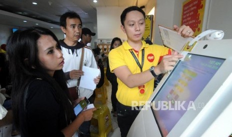 Petugas mengambilkan nomor antrian untuk warga yang akan melakukan registrasi ulang kartu SIM prabayar di Galeri Indosat, Kota Bogor, Jawa Barat, Rabu (28/2).