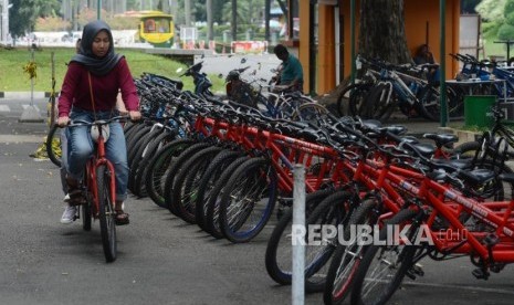 Pengunjung mengayuh sepeda di Taman Mini Indonesia Indah (TMII), Jakarta.