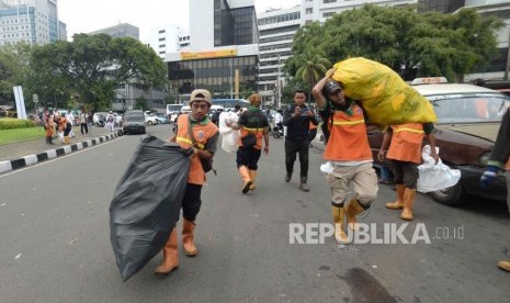 Petugas PPSU membersihkan sampah pasca aksi reuni 212 di kawasan Tugu Tani, Jakarta, Ahad (2/12).