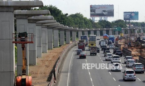 Penghentian Sementara Proyek. Sejumlah kendaraan melintas di samping lintasan jalur Light Rail Transit (LRT) di ruas tol Jakarta - Cikampek, Bekasi, Jawa Barat, Selasa (26/12).