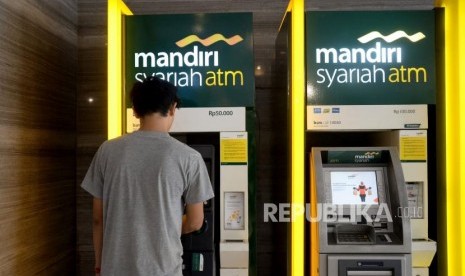 Nasabah melakukan transaks melalui ATM Bank Syariah Mandiri di Jakarta, Ahad (21/10).