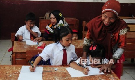 Warga menemani anaknya di dalam ruangan kelas pada hari pertama sekolah di SDN Mutiara, Desa Cibeber II, Leuwiliang, Kabupaten Bogor, Jawa Barat, Senin (16/7).