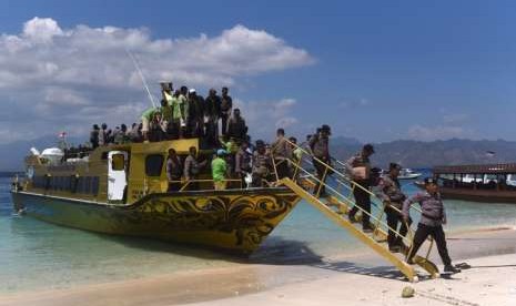 Sejumlah polisi menuruni kapal cepat setibanya di Gili Trawangan, Lombok Utara,  NTB, Kamis (9/8).