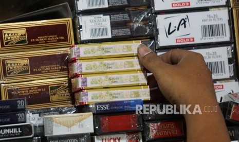 Pedagang menunjukan bungkus rokok bercukai di pasar Minggu, Jakarta, Ahad (15/9).