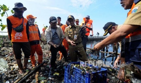 Gubernur DKI Jakarta Anies Baswedan mengambil sampah saat meninjau sampah yang menumpuk di Muara Angke, Jakarta Utara Senin (19/3).