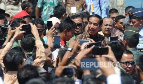 Presiden Republika Indonesia Ir Joko Widodo berjalan menyapa warga usai memberikan sambutan dalam acara puncak peringatan hari pers nasional 2018 di Danau Cimpago, Kota Padang, Provinsi Sumatra Barat, Jumat, (9/2).