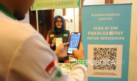 ZIS Digital Nahdliyin memindai QR Barcode untuk pembayaran zakat, infak dan sedekah secara non tunai melalui Go-Pay dalam peluncuran Kerjasama Strategis Pemberdayaan Ekonomi Umat berbasis Digital antara Gojek, Go-Pay dengan NU Care LazisNU di Jakarta, Selasa (16/7).