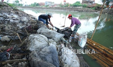 Dua penduduk berusaha mengangkat sampah Sungai Citraum, di Sektor enam program Citarum Harum Kodam III/Siliwangi, Kecamatan Bojongsoang, Kabupaten Bandung, Selasa (24/4).