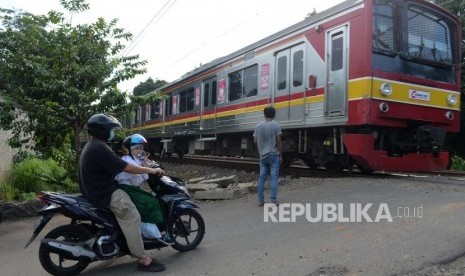  Perlintasan KRL. Sejumlah kendaraan menunggu KRL melintas di kawasan Pondok Ranji, Tangerang Selatan, Selasa (26/3).