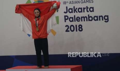 Pesilat Indonesia Sarah Tria Monita berfoto pada penyerahan medali usai menang bertanding melawan pesilat Laos Nong Oy Vongphakdy pada babak final cabang pencak silat putri kelas C 55-60 kg Asian Games 2018 di Padepokan Pencak Silat,TMII, Jakarta, Senin (27/8).