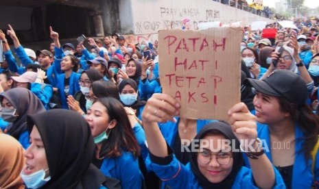 POSTER. Mahasiswa membawa poster bergerak menuju Gedung DPR  sesaat sebelum aksi di depan Kompleks Gedung Parlemen RI berakhir dengan bentrok, Selasa (24/9).