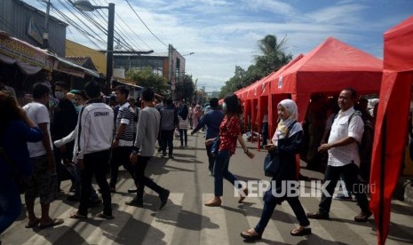 Pejalan kaki melintas diantara tenda yang akan digunakan pedagang ketika dilakukanya penutupan Jalan Jatibaru di Kawasan Tanah Abang, Jakarta, Jumat (22/12).