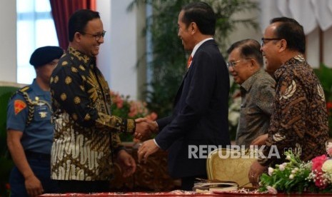 Presiden Joko Widodo berjabat tangan dengan Gubernur DKI Jakarta Anies Baswedan seusai mengumumkan pemindahan ibukota negara di Istana Merdeka, Jakarta, Senin (26/8).