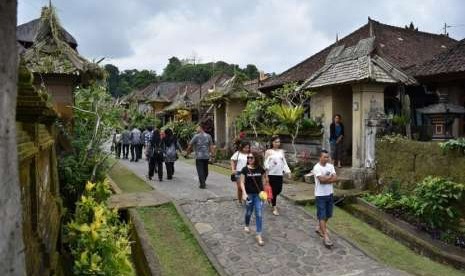 Sejumlah wisatawan mengunjungi Desa Adat Penglipuran di Kubu, Kabupaten Bangli, Bali, Kamis (19/7).