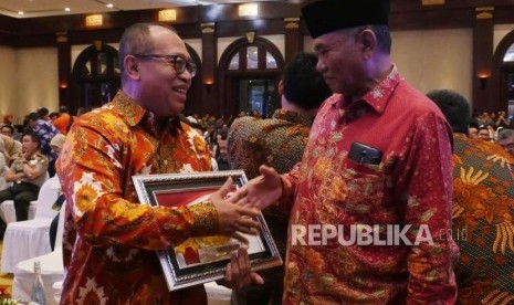 Ketua KPK Agus Rahardjo (kanan) memberikan ucapan selamat kepada Direktur Utama BPJS Ketenagakarjaan Agus Susanto usai menerima penghargaan pada acara peringatan Hari Anti Korupsi Sedunia 2017 di Jakarta, Selasa (12/12).