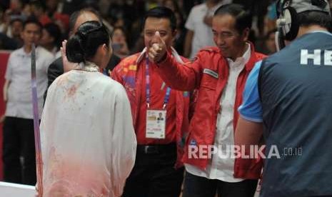 Presiden Joko Widodo memberikan salam kepada atlet wushu Indonesia Lindswell Kwok usai bertanding di cabang wushu nomor taijijian Asian Games 2018 di Kemayoran, Jakarta, Senin (20/8).