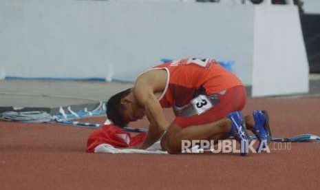 Sprinter Indonesia Sapto Yogo Purnomo bersujud usai menjuarai final 100 meter putra T37 Asian Para Games di Stadion Utama Gelora Bung Karno, Senayan, Jakarta, Selasa  (9/10).