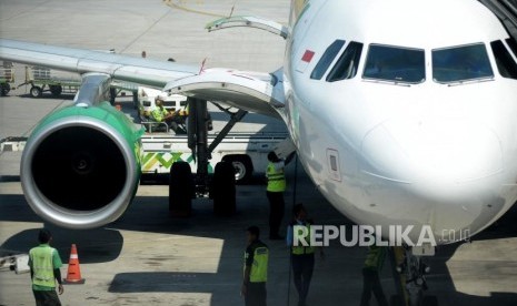 Petugas menurunkan bagasi milik penumpang pesawat di Bandara Internasional Ahmad Yani,Semarang,Jawa Tengah,Rabu (10/7).