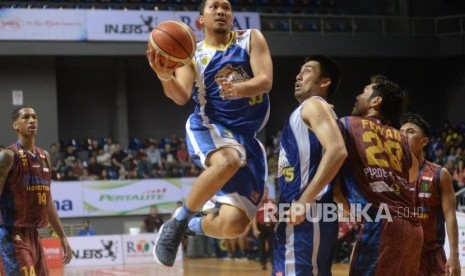 Pebasket Satria Muda Pertamina Arki Dikania Wisnu berusaha melewati hadangan pemain BSB Hangtuah pada semifinal game ketiga IBL di Britama Arena, Jakarta, Ahad (25/3).