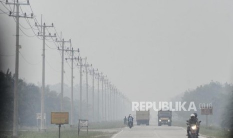 Sejumlah kendaraan melintas saat kabut asap kebakaran hutan dan lahan menyelimuti Kota Pekanbaru, Riau, Selasa (10/9).