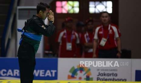 Pesilat Indonesia Komang Harik Adi Putra (pita biru) memberikan salam usai bertanding melawan Pesilat Singapura Muhammad Shakir Juanda pada babak perempat final cabang pencak silat putra kelas E 65-70 kg Asian Games 2018 di Padepokan Pencak Silat TMII, Jakarta, Jumat (24/8).