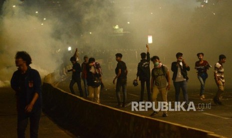 Massa Aksi Mahasiswa Indonesia berlari menghindari gas air mata saat aksi di depan kawasan Jalan Tol Dalam Kota Gatoto Soebroto, Jakarta, Selasa (24/9/2019).