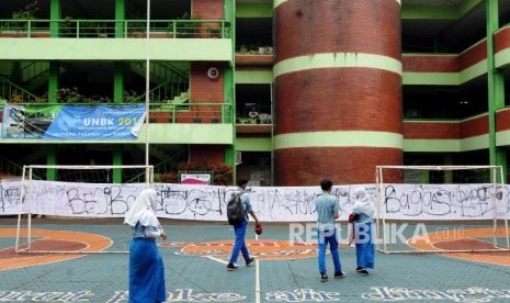 Pelajar saat akan membubuhkan tanda tangan di kain putih usai pelaksanaan Ujian Nasional Berbasis Komputer (UNBK) di SMP Negeri 56 Jakarta, Cilandak, Jakarta, Kamis (26/4).