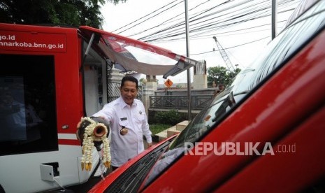 Kepala BNN Komjen Pol Budi Waseso menyiram air ke mobil pencegahan BNN  dalam peluncuran mobil di Kantor BNN, Jakarta, Rabu (27/12).