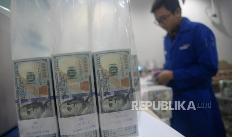 Karyawan menghitung tumpukan uang dolar Amerika Serikat di Cash Center Bank Mandiri, Jakarta.ilustrasi