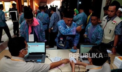 Petugas memeriksa riwayat kesehatan calon jamaah haji melalui kartu kesehatan di Asrama Haji Bekasi, Bekasi, Jawa Barat, Rabu (25/7).