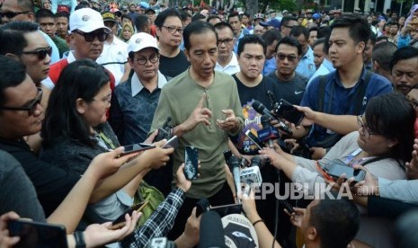 Presiden Ri Joko Widodo (Jokowi) diwawancara wartawan usai menyapa pengunjung Car Free Day (CFD) Dago, Kota Bandung, Ahad (11/11).