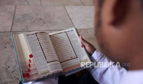 Seorang pelajar membaca Alquran seusai salat Jumat di Masjid Istiqlal, Jakarta.