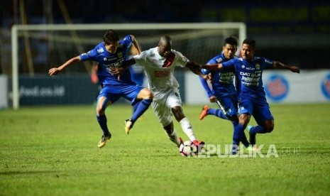 Striker PSM Makassar Djite Bruce Jose diadang tiga pemain Persib Bandung pada pertandingan Grup A Piala Presiden 2018 di Stadion Gelora Bandung Lautan Api Bandung, Jumat (26/1).