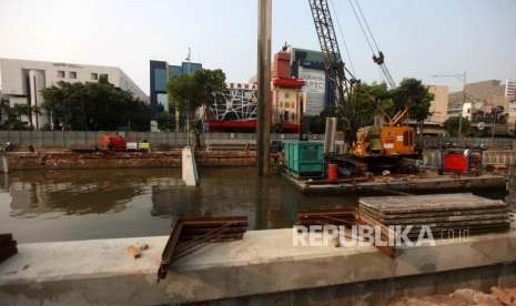 Pekerja dari Dinas Sumber Daya Air Pemerintah Provinsi (Pemprov) DKI Jakarta mengoprasikan alat berat saat memasang turap di Kali Ciliwung lama, Jalan Veteran, Jakarta, Rabu (10/10).