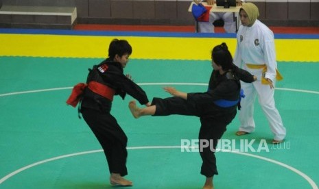 Pesilat putri Indonesa Nirmalasari Oktaviani  (kiri)  menahan tendangan dari pesilat putri  Laos Olathai   Sounthavong dalam  pertandingan babak semifinal kelas 50-55 kg putri pencak silat 18th Asian Games Invitation Tournament di Padepokan Pencak Silat TMII, Jakarta, Senin (12/2).